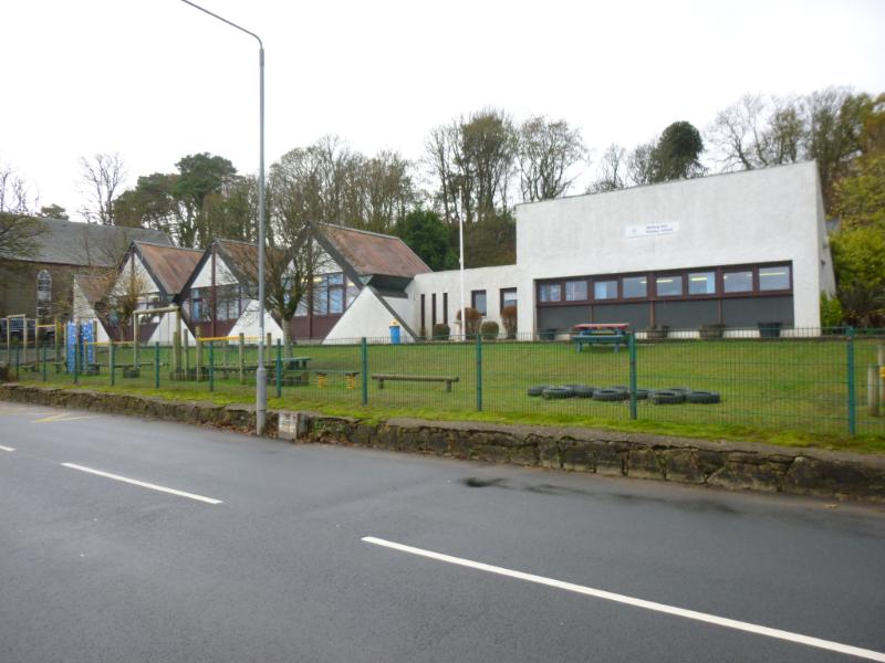 Whiting Bay Primary School, principal elevation looking east, taken from northeast during daytime with cloudy sky with road in front.