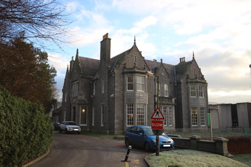 Garthdee House, west elevation, looking northeast, during daytime, on clear day, with a blue car in front of the building. 