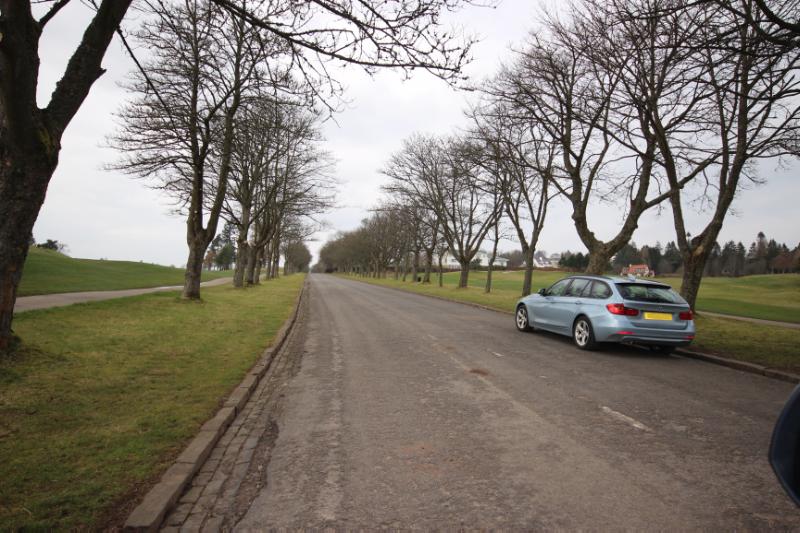 old road from station to hotel, looking northwest, during daytime, with cloudy sky. 