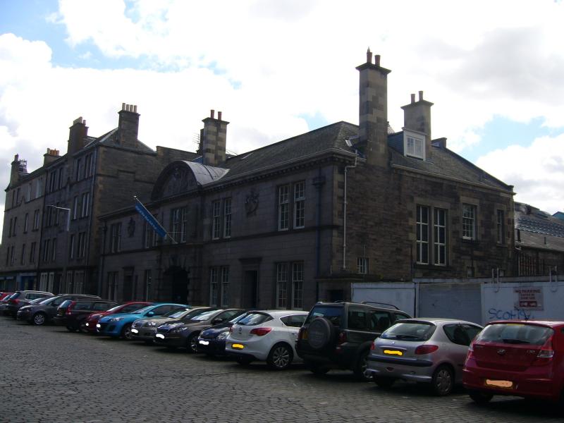 The Out of the Blue Drill Hall, Dalmeny Street front and side elevations with parked cars in front of building, looking north on a sunny day with blue sky and clouds