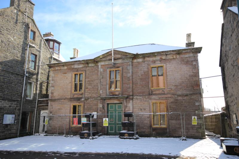 Former Kingussie Sheriff Court principal elevation, looking southeast, during daytime, on partially cloudy day with snow on the ground and the roof
