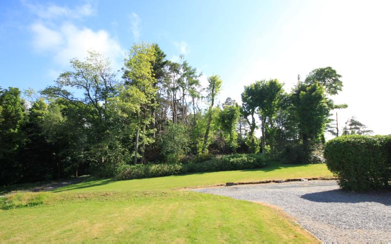 Garden at Kyle House, Isle of Skye, looking south on clear day with blue sky.