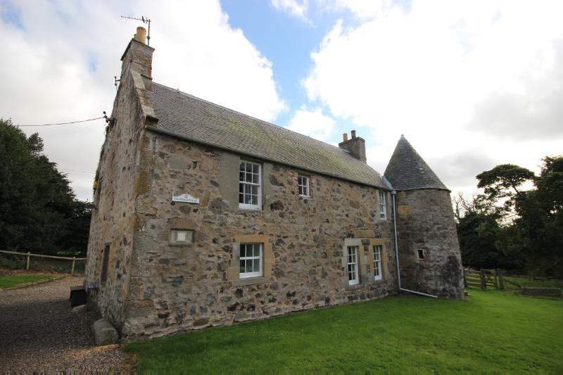 Feather House at Mountquhanie Castle, view from northeast showing corner tower, during daytime on a cloudy day.