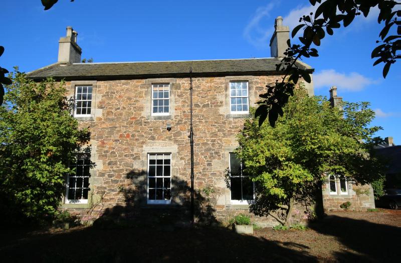 Drem Farmhouse, looking north during daytime, on clear day with blue sky.