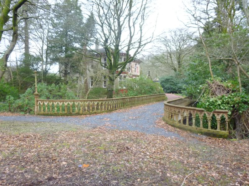Iron bridge to south of Doggartland House, Dalry, during daytime on dull day and with Doggartland House in background.
