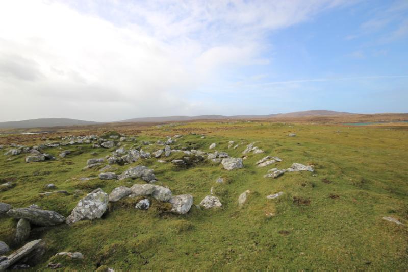 Geirisclett, showing substantial arc of walling, looking south-southwest, during daytime with blue sky