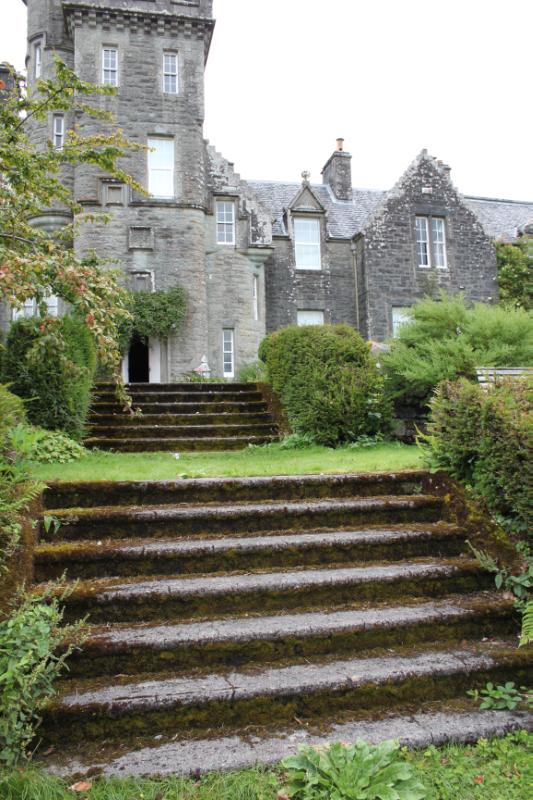 Achnacloich, view up steps of terraced gardens, looking north, during daytime, on clear day with cloudy sky. 