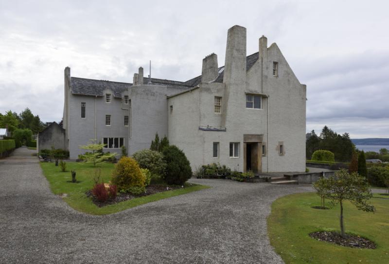 Hill House, entrance and rear elevations, looking southeast, during daytime with plants in front of the building
