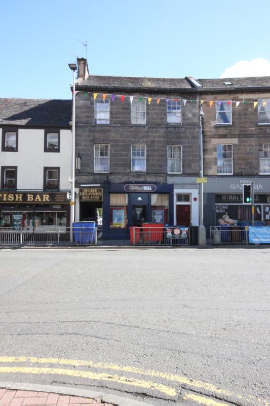 116 and 118 High Street, principal elevation to the High Street, looking southeast during daytime, with street furniture and bins in front of the building. 