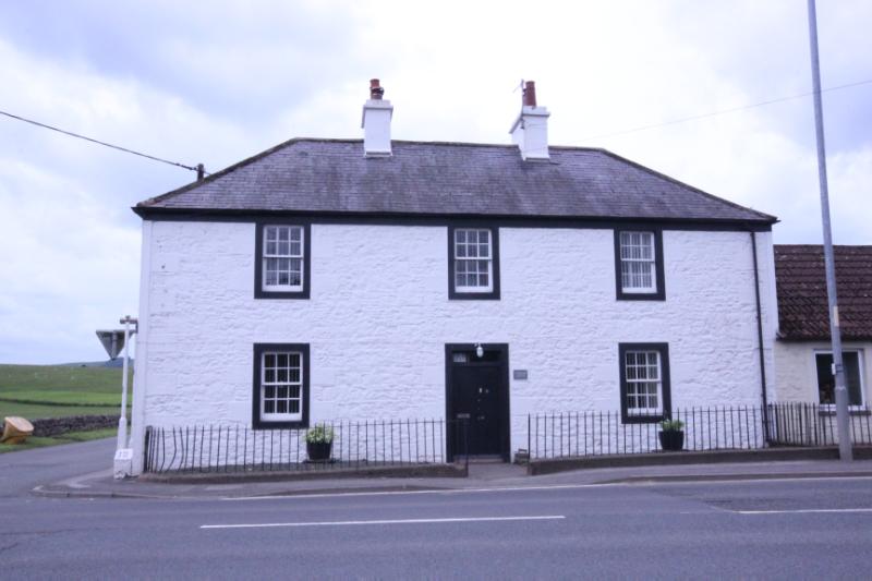 Corner House, principal elevation, looking southwest, during daytime on a cloudy day.