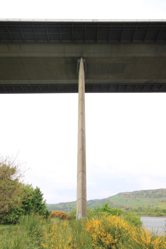 Erskine Bridge, detail of narrow supporting pier and pier top access platform, during daytime with cloudy sky.