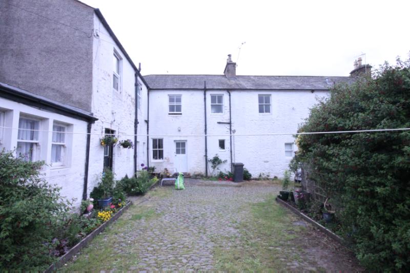 Nos 2 and 3 The Cross, Penpont, rear elevation, with rear wing and cobbled yard looking south, during daytime with white sky.