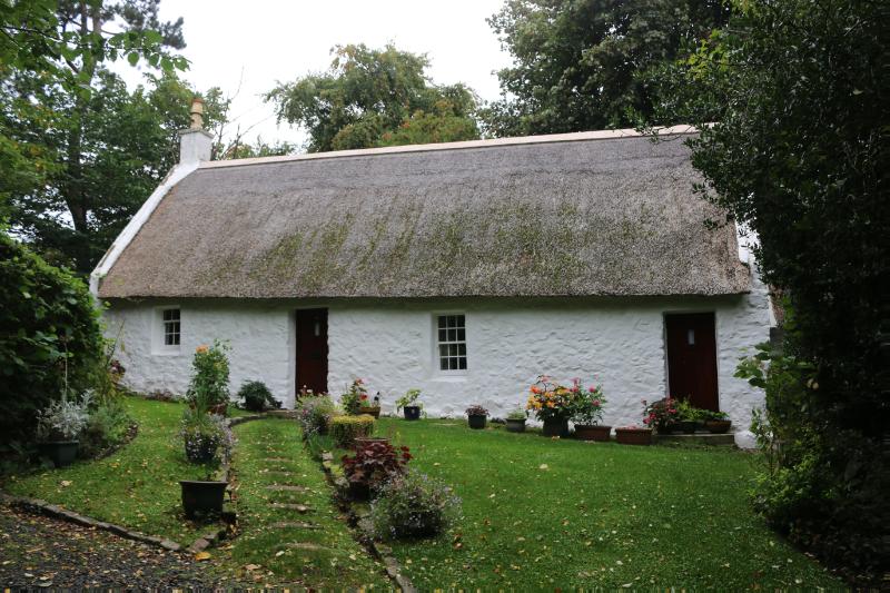 11 Swanston Village, main elevation, looking west on an overcast day and surrounded by trees.