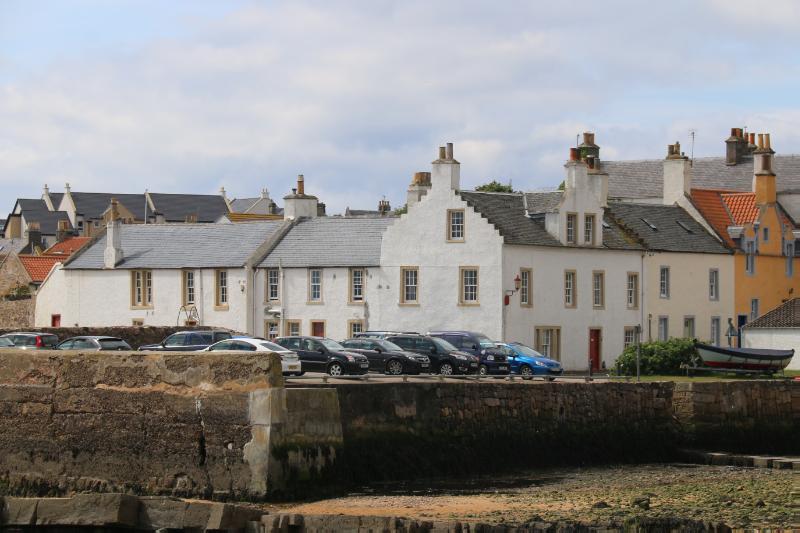 The White House / Merchants House and No3, Shore, Anstruther Wester, looking west across the harbour from Anstruther Easter, during daytime with partly cloudy sky.