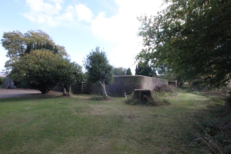 Lunan Bank Walled Garden, northwest wall, looking southeast, during daytime with blue sky.