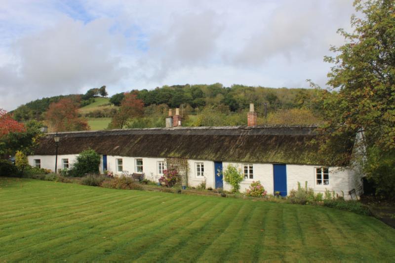 Old Burnside Cottages, front (south) elevation, looking north from garden plot, during daytime, on cloudy day. 