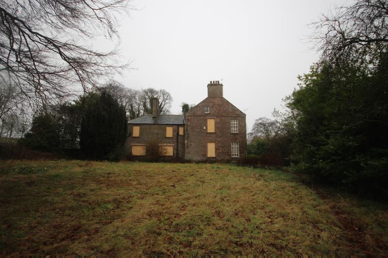 : Leuchland Farmhouse, southwest elevation, looking northeast, with bushes and trees around the building, during daytime.