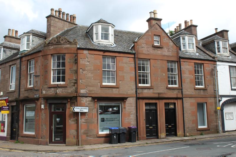 1 and 3 Alma Place and 17 High Street, corner (west) elevation, looking east during daytime, on a cloudy day, with rubbish bins and signpost in the foreground.