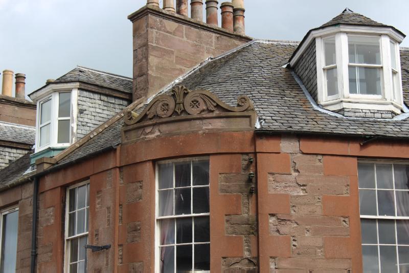 1 and 3 Alma Place and 17 High Street, detail of pediment over bow front, looking east during daytime, on a cloudy day.