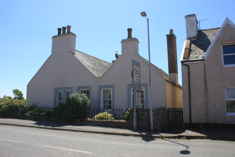 Ivy Cottage, north elevation looking south, during daytime with blue sky.