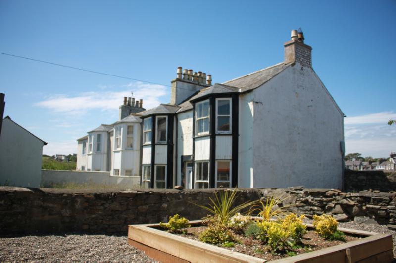 9A, 9 and 11 Main Street, Isle of Whithorn, principal east elevation looking southwest during daytime, on clear day with blue sky. 