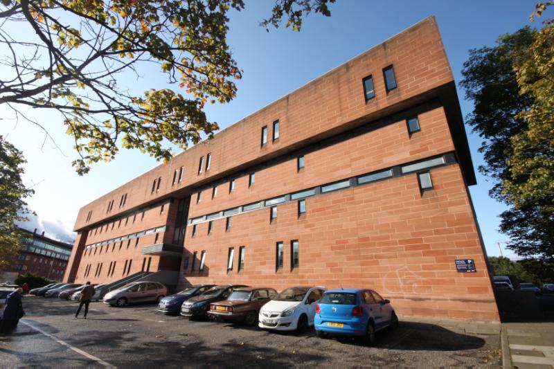 Hunter Building, Lauriston Place (south) elevation, looking north, during daytime with cars parked in front of the building.