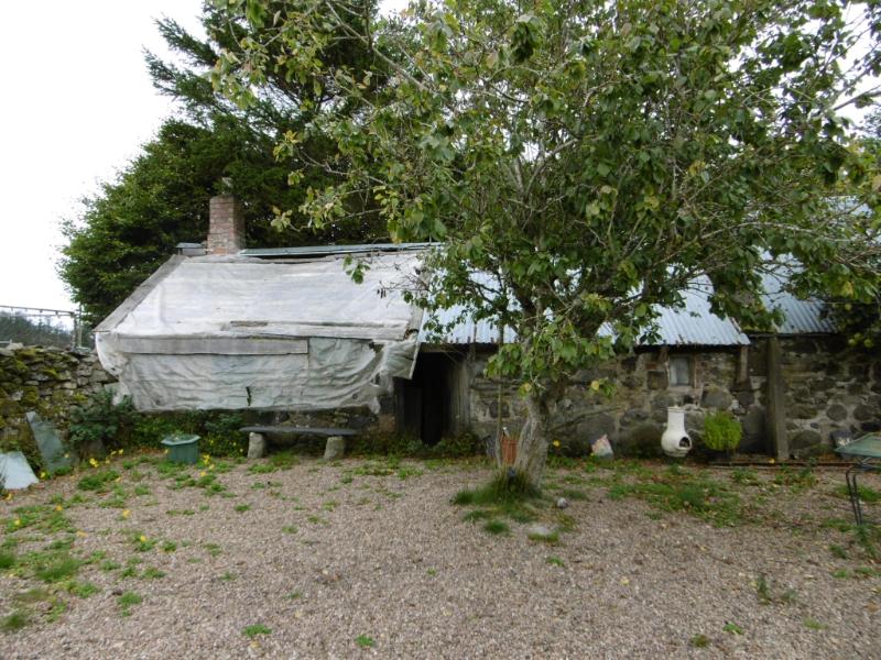 West outbuilding at Corse Croft, south part of principal elevation, looking northwest during daytime with trees in front of the building
