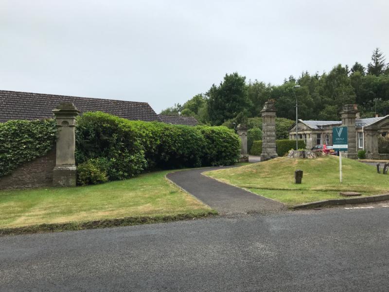 East Lodge gatepiers and entranceway at Letham Grange with East Lodge in background, looking west, during daytime on overcast day.