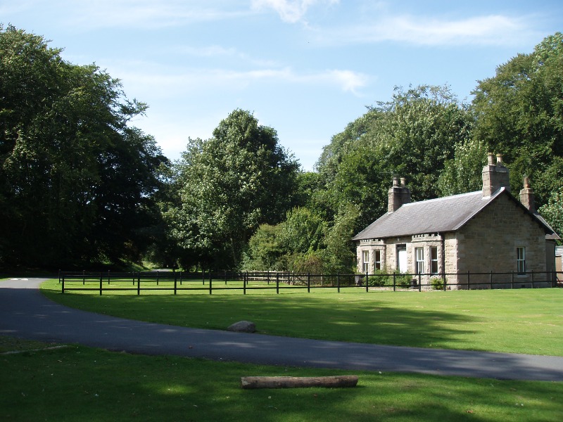 Carpenter’s Cottage, Haddo House, looking northwest, background of trees and blue sky, lawns in shadow to front. 