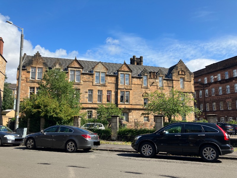 Former police station buildings, south elevation, looking north, during daytime with blue sky.